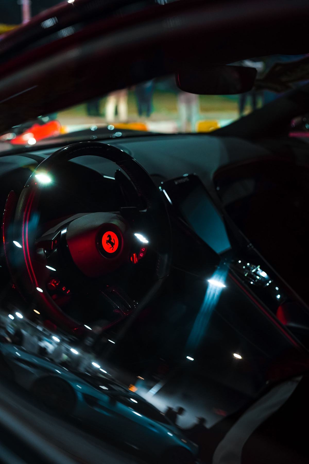 Ferrari cockpit with steering wheel and dashboard at night