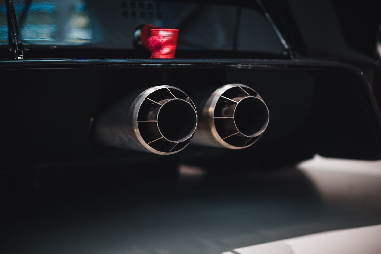 Twin exhaust outlets on a dark performance car