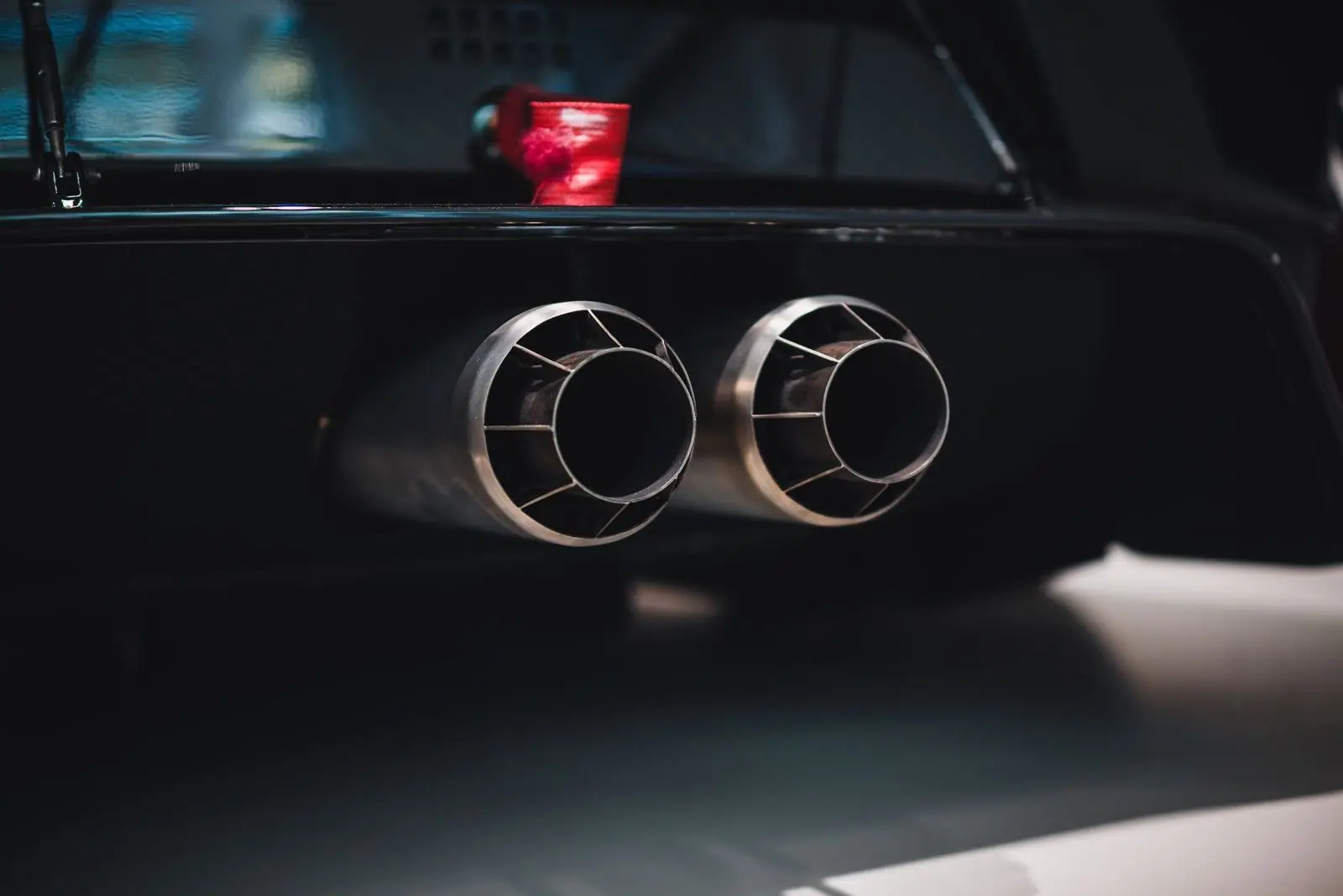 Twin exhaust outlets on a dark performance car